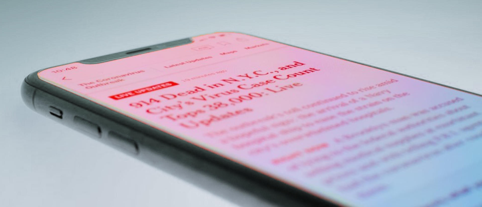 smartphone displaying COVID news article on screen