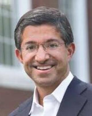 Bharat Anand standing outside a Harvard building