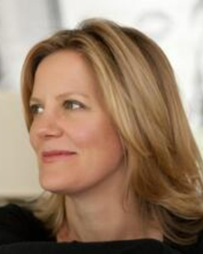 Heidi Legg sitting sideways on a chair, resting her arm on the back